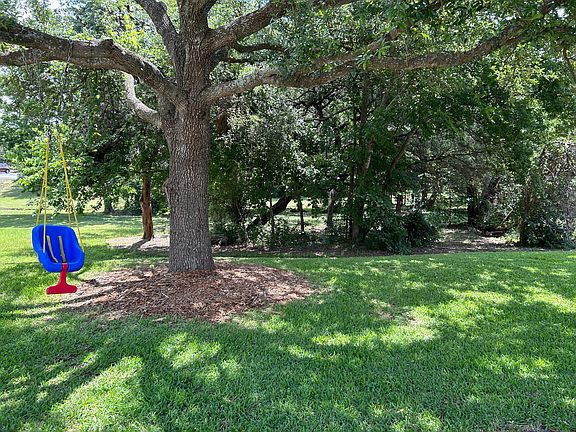 Front Yard and Child Swing along with view of what seems like an extension of the front yard. (property of hoa)