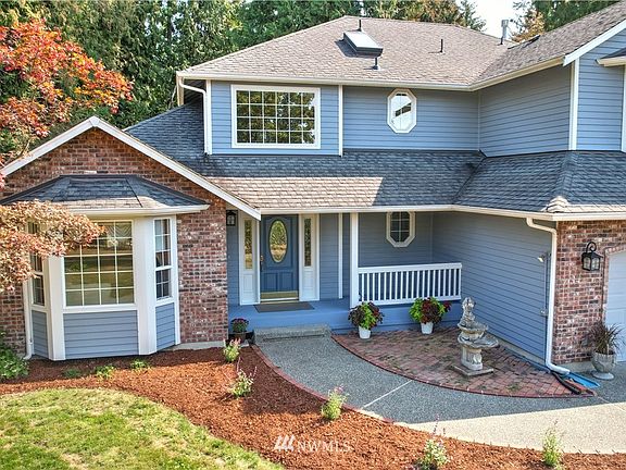Beautiful Northwest traditional home features gorgeous brickwork and a covered front porch that will both impress your guests and keep them dry!