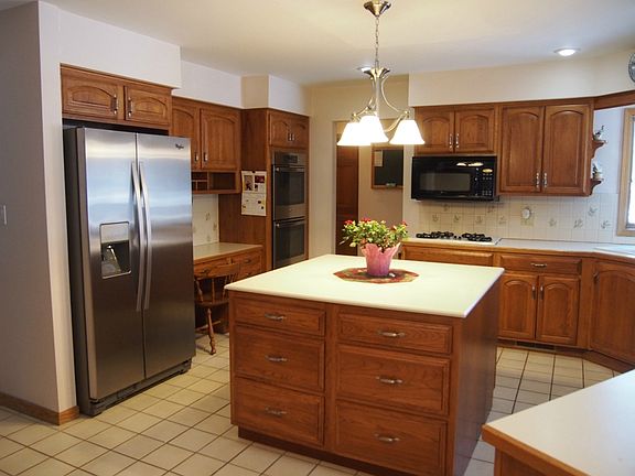 This spacious kitchen is loaded with storage.  A new stainless refrigerator and double oven have just been installed.  The kitchen eating area with wood flooring leads to a nicely sized deck.