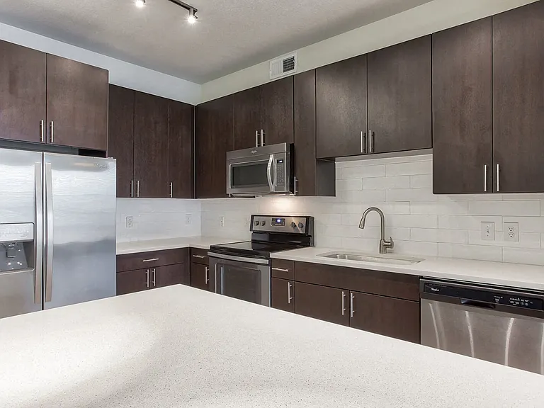 Espresso cabinets and white subway tile creates a modern kitchen