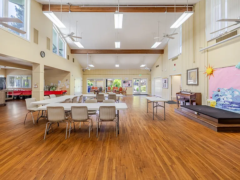 Multipurpose space with high ceilings, bright windows, and room for community activities.