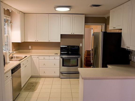 Updated eat-in kitchen with stainless steel appliances and ceramic tile floors