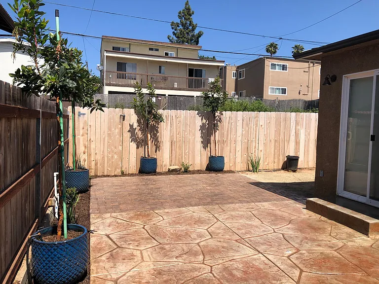 Backyard has hard surface and planted areas with lots of sideyard storage.