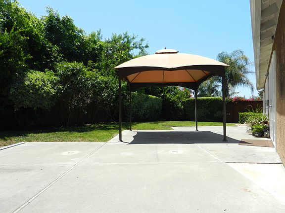 Lush private backyard looking toward downstairs master bedroom French doors. Large patio for entertaining.