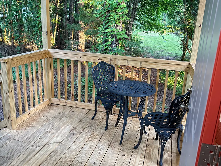 back covered porch with iron bistro table and 2 chairs.