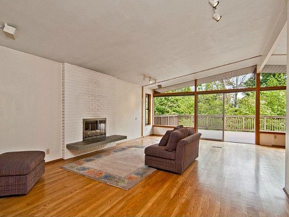 C'mon in to the well lit, vaulted ceiling living room! You feel like you're in the woods! Hardwood floors are in good shape!