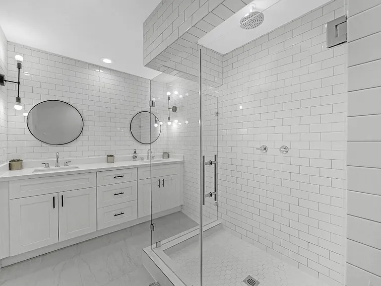 Primary suites bathroom with a large shower double sink and bathroom