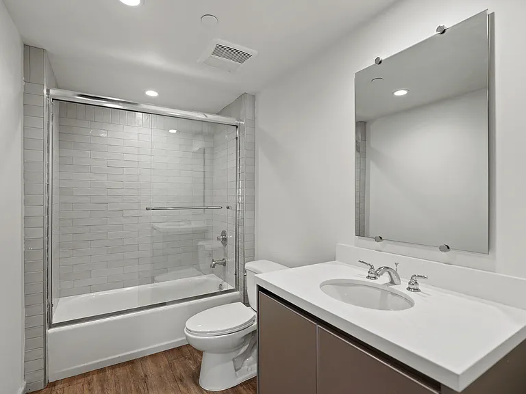 Bathroom with Shower Bath with Glass Door, and Vanity Cabinet Storage