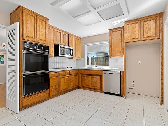 Kitchen featuring a charming garden window, 2 ovens, dishwasher, microwave and breakfast nook area