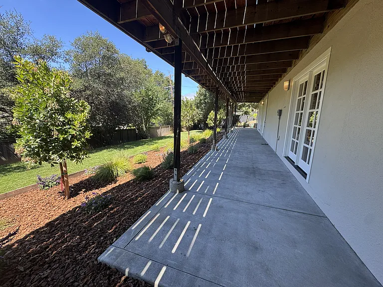 concrete patio adjacent to bedroom 4 and Family/den/office/game room.