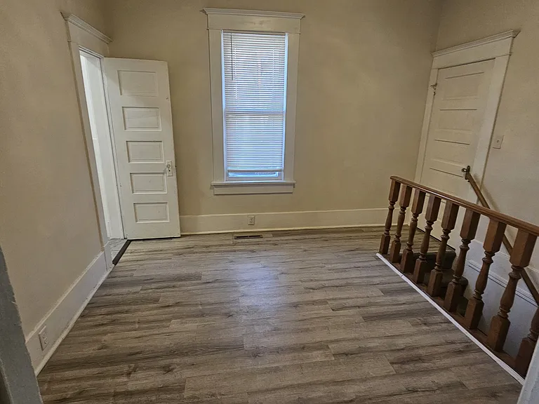 This is the additional upstairs study/living room. Bathroom to the left and a coat closet to the right. Stairs leading you to the basement.