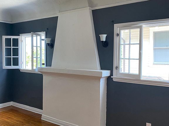 Living room area with chimney and windows that offer natural lighting.