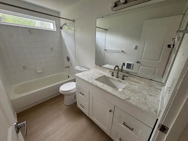 Full guest bathroom featuring a large vanity, tub/shower combination, and plenty of storage.