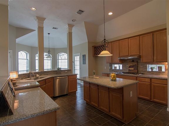 This kitchen has lots of counter space, cabinets and an island for meal preps and storage.