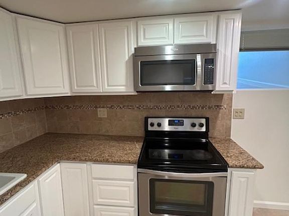 Kitchen with microwave with electric stove and oven