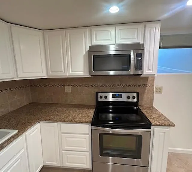 Kitchen with microwave with electric stove and oven