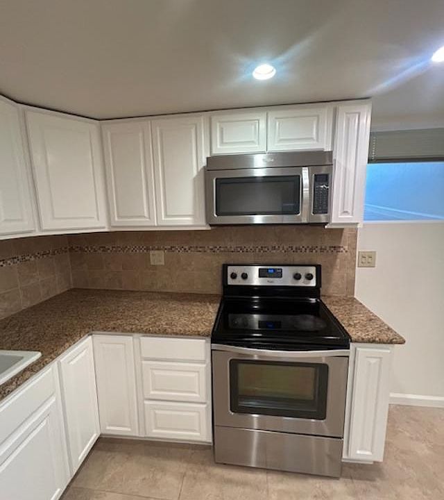 Kitchen with microwave with electric stove and oven