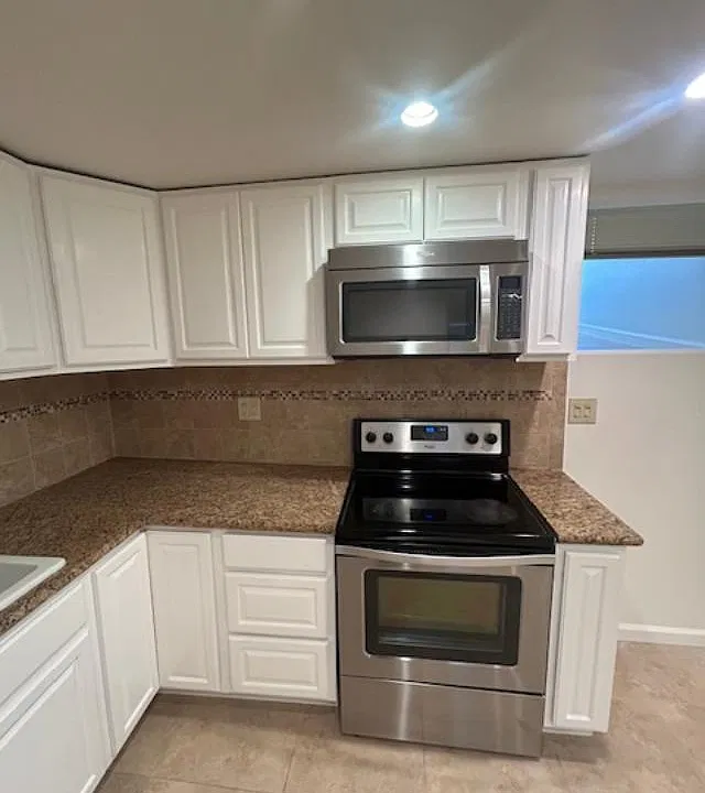 Kitchen with microwave with electric stove and oven