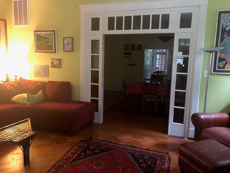 Other half of living room showing Arts and Crafts design and comfortable couch, looking toward dining room and kitchen.