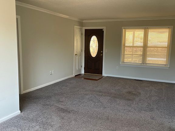 Living room with front door view and closet.