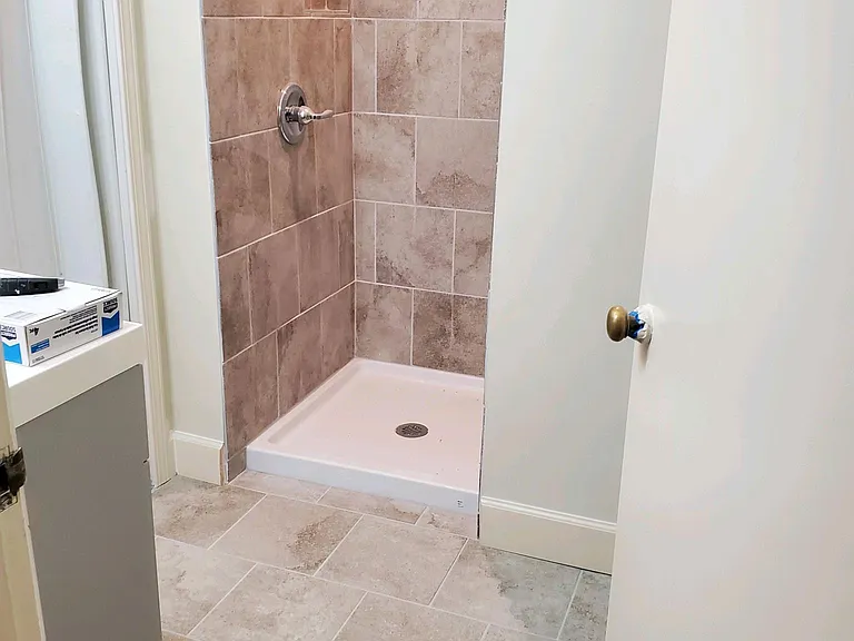 Room A and C Shared Bathroom - walk in shower, toilet behind door, counter and mirror to the left