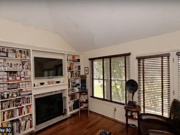 Living room with fire place and enough storage. Has tons of shelves. And door to patio.