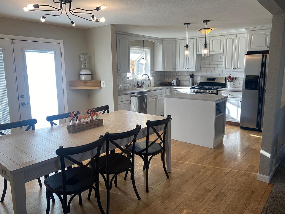 Updated kitchen features new countertops, subway tile backsplash and light fixtures. Double french doors lead to large deck with view of open space.