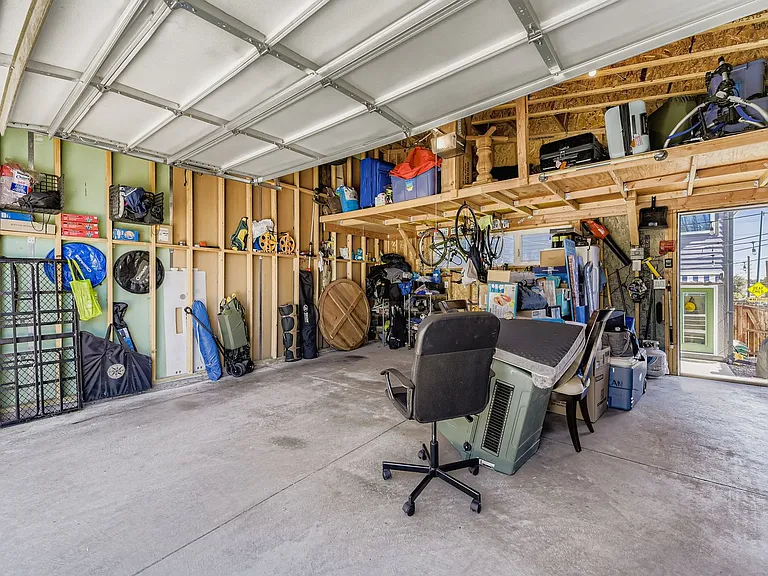 2-car detached garage with ample storage in elevated storage area with drop-down ladder