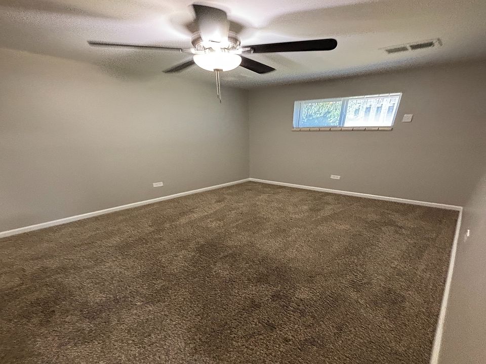 Inviting bedroom with fresh beige carpet, cozy atmosphere, and a modern ceiling fan for perfect comfort.