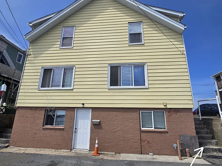 Front view of four family home. Right staircase to unit 1R