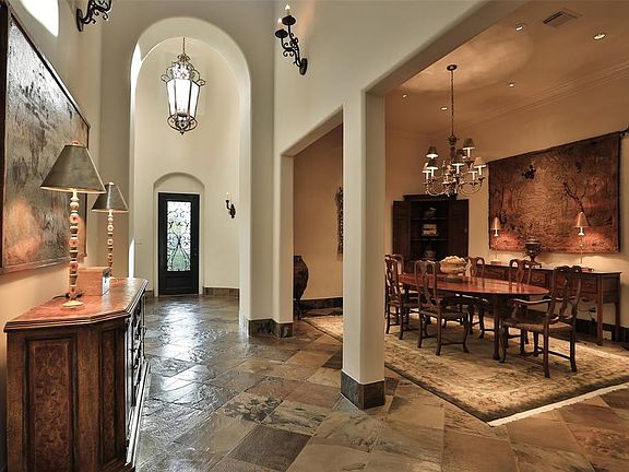 STRIKING ATTENTION TO EVERY DETAIL IS EVIDENT THE MINUTE YOU ENTER - Towering ceilings add drama to a magnificent entry and dining space that completely opens to a two-sided fireplace (not shown). This room was once a courtyard in the builders plans.