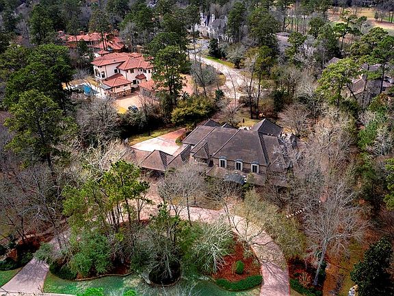 Privately tucked away behind the gates of Carlton Woods, this home features a circle driveway and a rear gated driveway to the street behind!