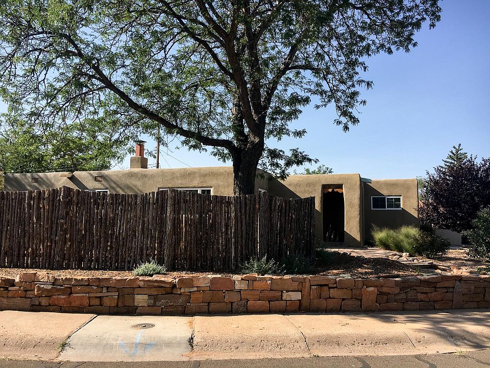 Fenced in front yard with mature trees in established neighborhood.