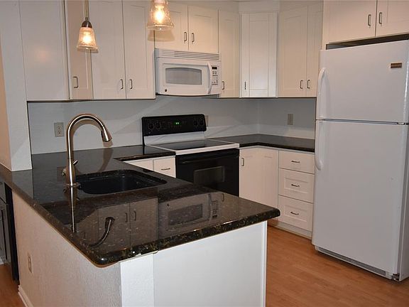 Updated kitchen with granite counters and pendant lights