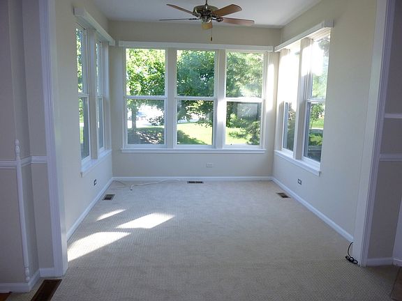 Spacious Sunroom off Living Room with fan and overlooks open area