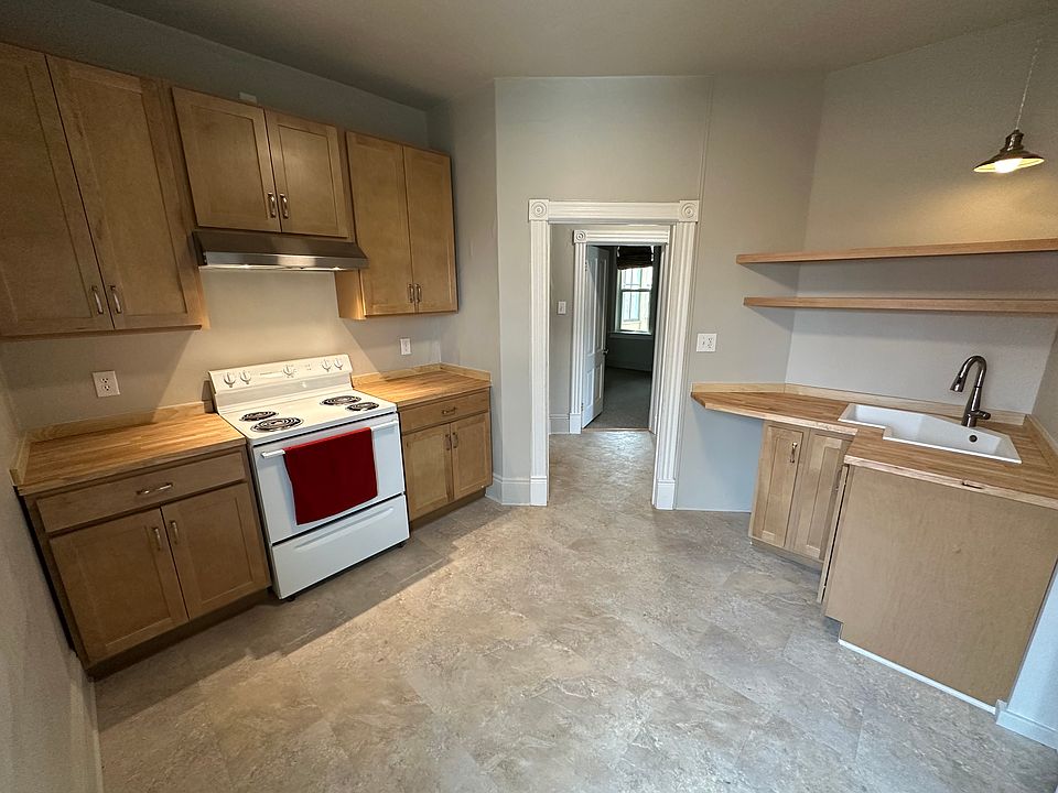 Modern kitchen. Butcher block counters, new LED lighting and range hood, and new vinyl plank flooring.