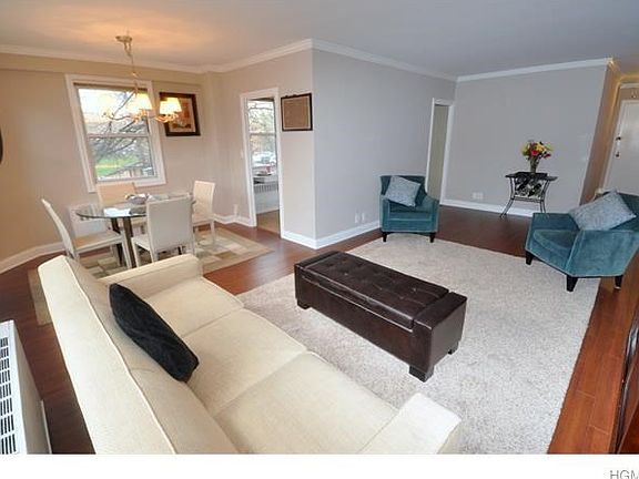 The Bright and sunny living room has crown molding and opens to both a dining area and entry foyer.  The living room is 23'-1" x 12'-0" and the dining area is 10'-6" x 8'-4", the entry foyer is an additional 12'-0" x 9'-1"