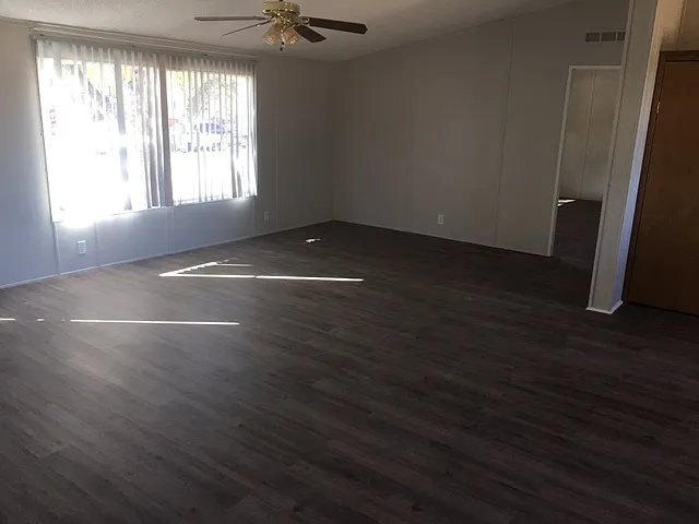 Living room with big windows and ceiling fan.