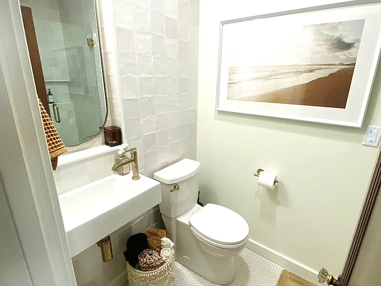 The ground floor bathroom, conveniently located just steps from the kitchen and main floor bedroom, features beautiful handmade tile throughout. Enjoy the beautiful walk in shower and all the essential amenities you'd expect from a boutique hotel.