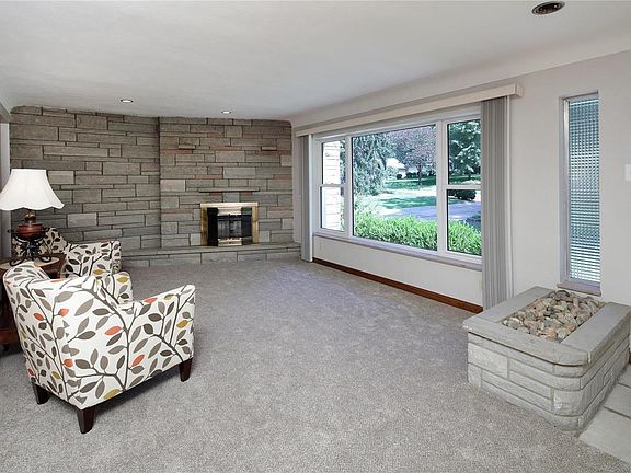 Living room has brand new carpet. Stone planter and stone wall with fireplace.  Cove ceiling and fresh paint!