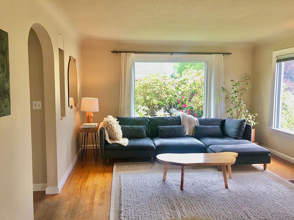 Living room with large windows, coved ceilings.