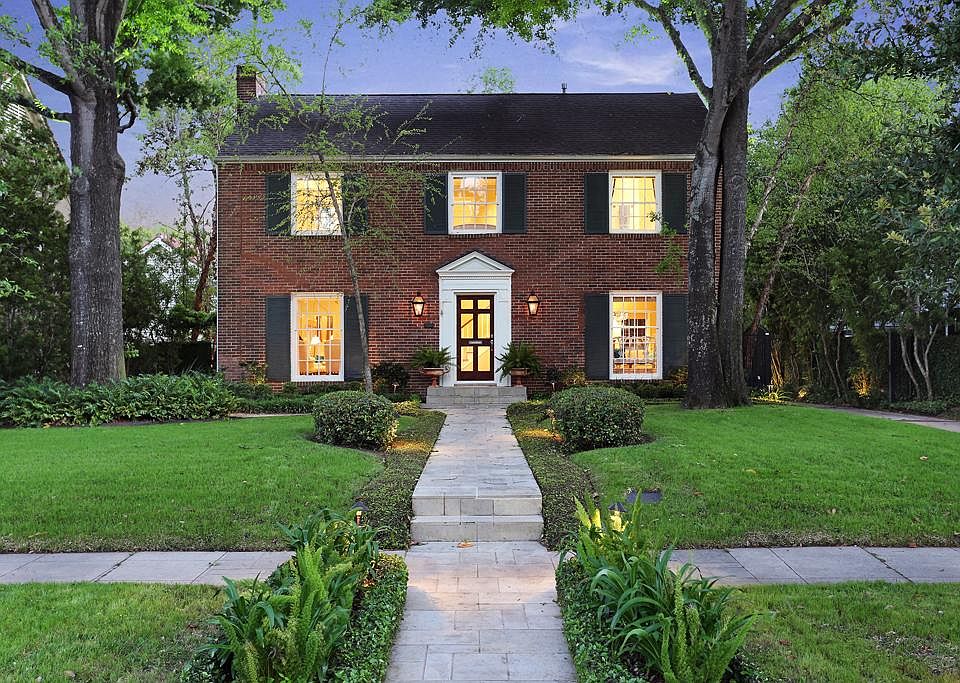 Classic River Oaks home with mature trees, landscape lighting limestone walkways and gas lanterns on