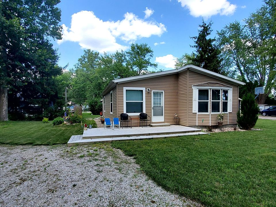 Gravel driveway with ample parking and large patio.