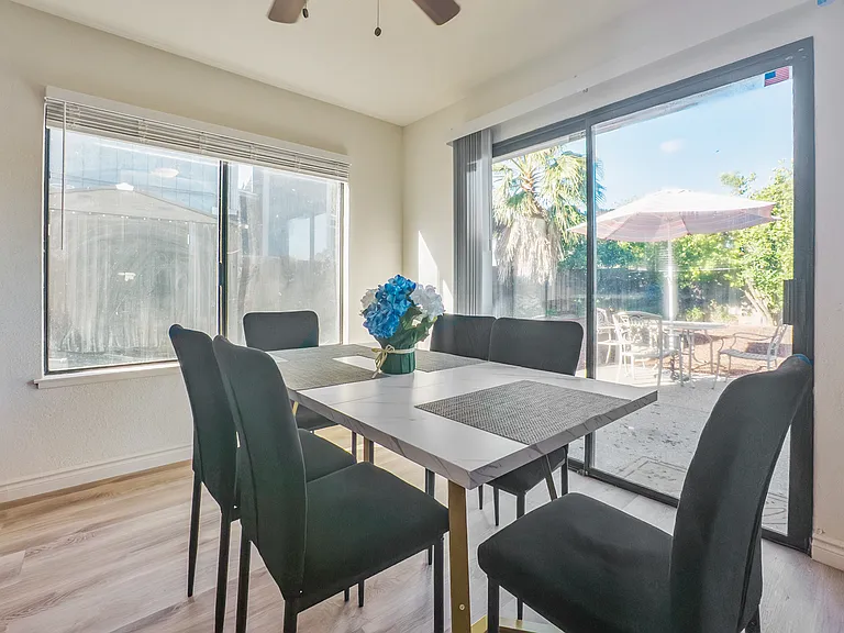 The inviting dining area features a table with seating for six, perfectly positioned next to the kitchen with serene views of the patio and backyard.