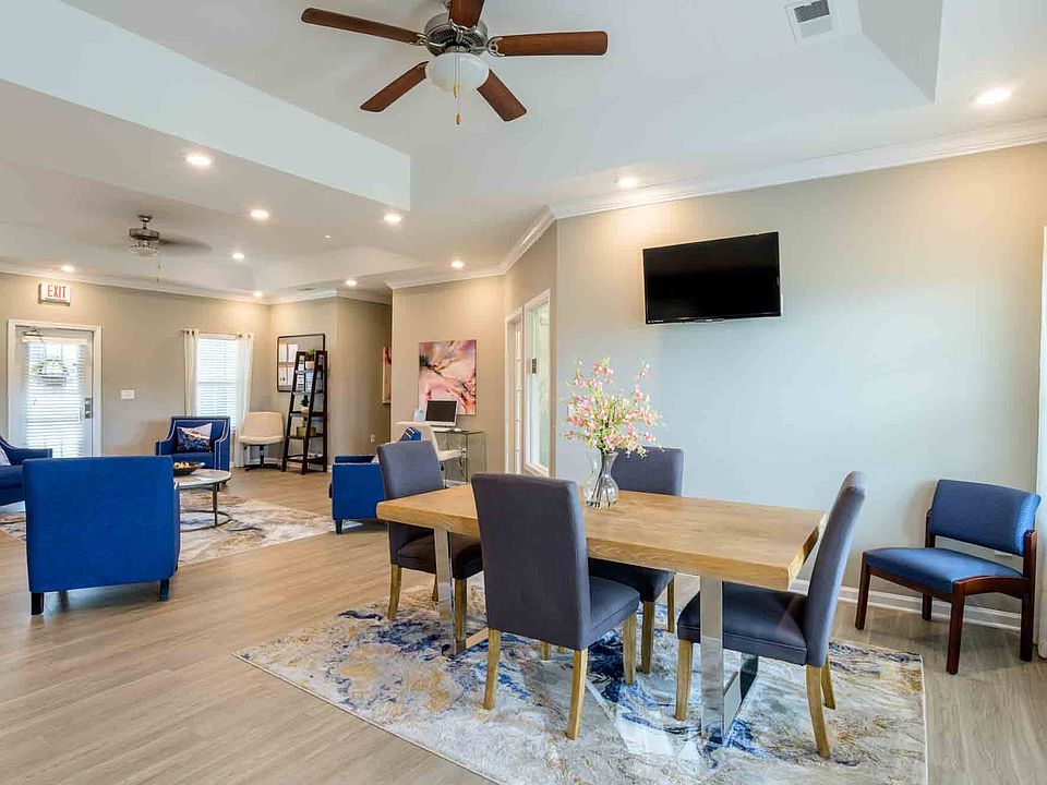 Spacious community lounge with ample seating, wall-mounted TV, and natural lighting, perfect for meetings or resident events at Cedar Terrace Apartments.