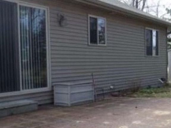 Patio door off dining area faces small fenced yard