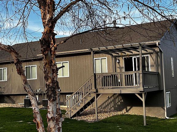 Large backyard with deck, pergola, fresh landscaping and hose attachment for flowers / plants