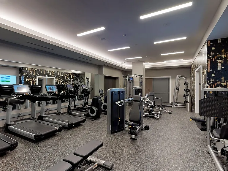 Club-quality fitness studio including cardio equipment with individual TV's