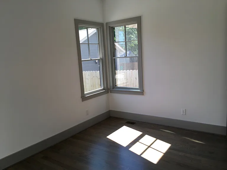 Downstairs primary bedroom has hardwood floors and its own bathroom down the hall from the kitchen (note: the paint color for this room only varies from this photo)