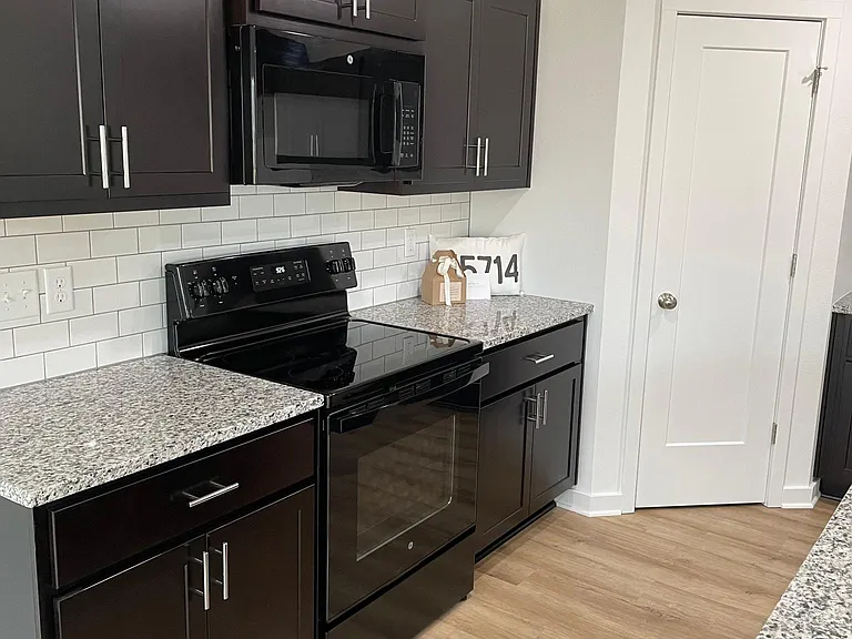 Kitchen with all new appliances, walk in pantry, island, granite countertops and subway tile backsplash.